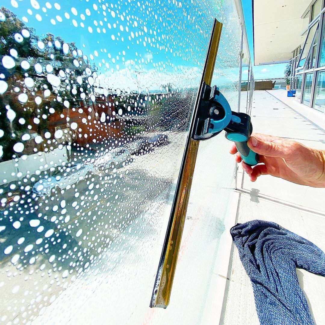 Professional window cleaner making windows sparkle on a sunny day